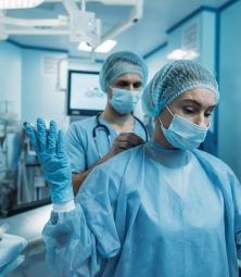 stock-photo-doctor-helping-wear-surgical-uniform